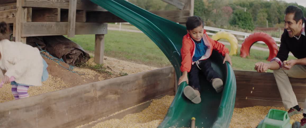 A small child is sliding down a playground slide