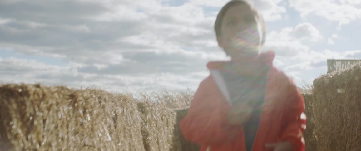 Young children run through a hay maze