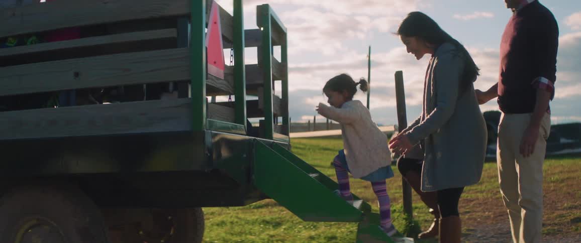 A family goes on a tractor ride on a farm