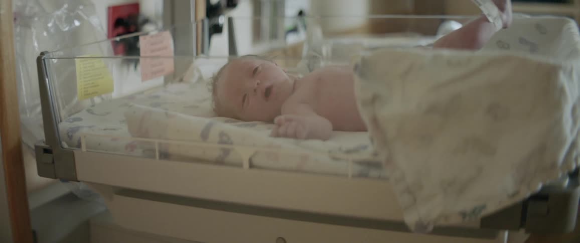 A newborn in a hospital bassinet