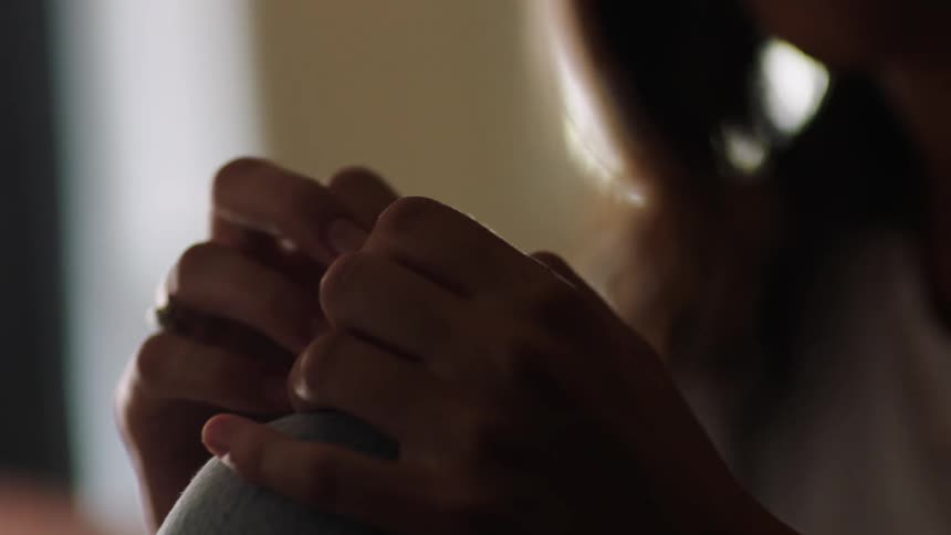 A close up shot of woman sitting and rubbing her hands together