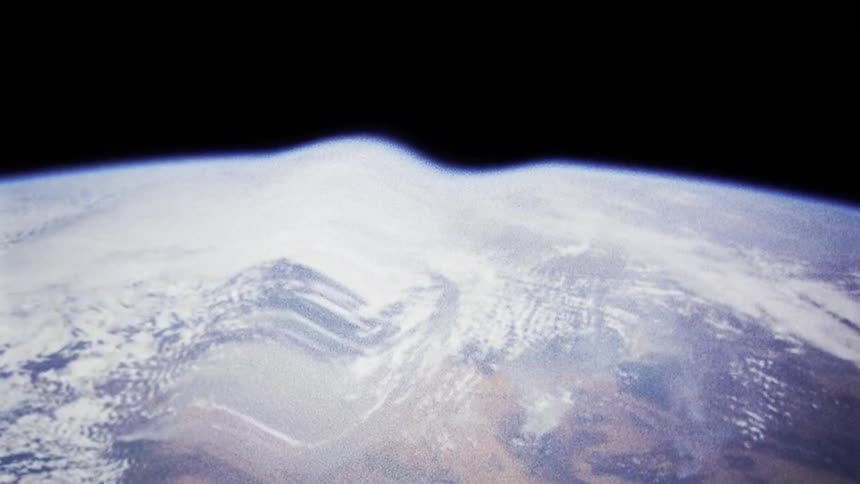 The planet earth as visible from outer space is warped and distorted with a large rippled across it