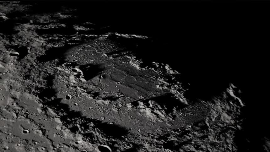 Long shadows are cast by mountains on the crater marked surface of the moon