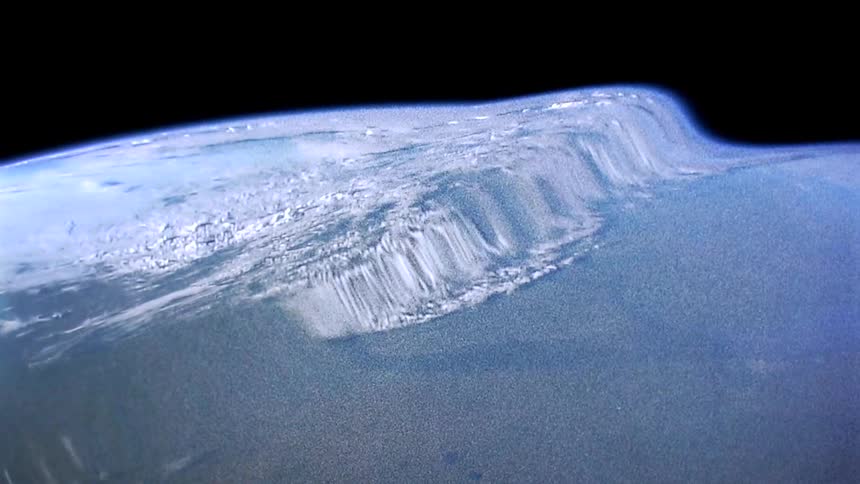 The surface of the earth appears to ripple and wave against the black of space