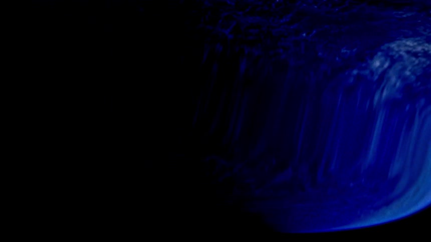 A dark blue planet can be seen from outer space but its image appears heavily warped and distorted