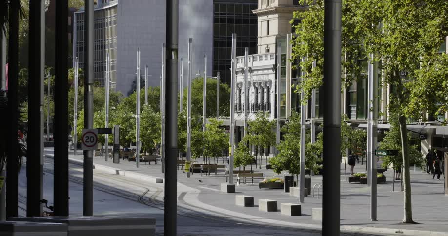 People stand and walk around plaza near empty street and buildings