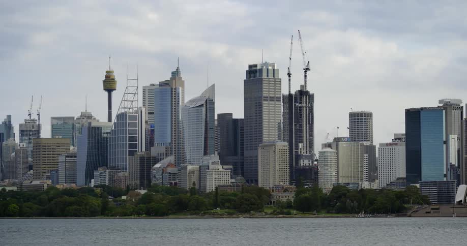 Big city skyline from a distance with tall buildings and skyscrapers by a river on the horizon