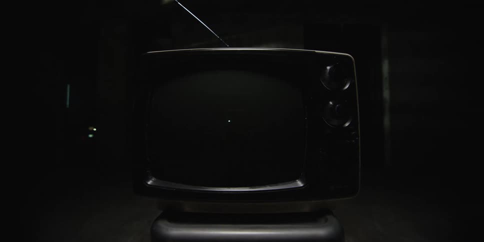 Old television shows static then shuts off in dark room