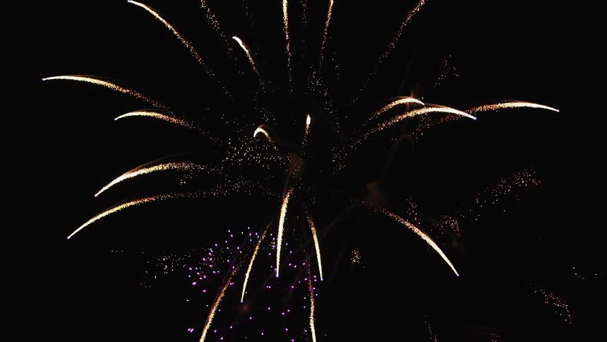 Fireworks fly up into night sky before exploding into colorful patterns