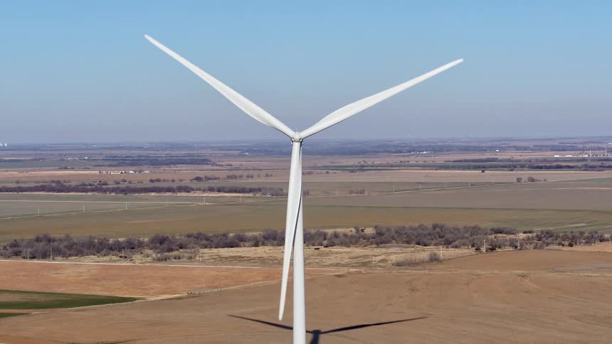 A wind turbine rotates on a rural wind farm in the daytime