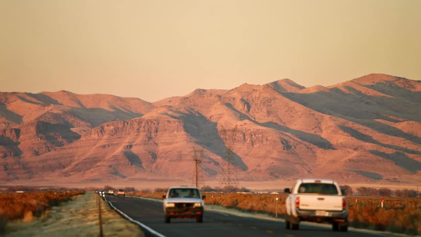 Vehicle driving on a street in front of a mountain range