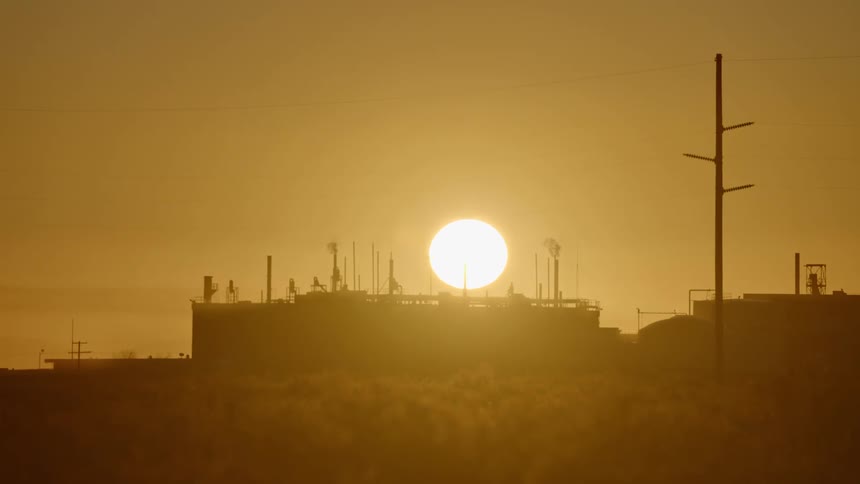 The sun setting over a factory