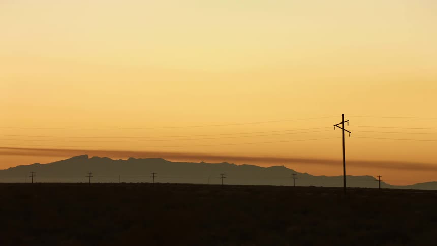 An orange sky over a vast grassland in the countryside at sunset