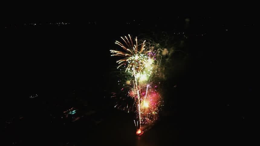 Colorful fireworks explode against a black sky