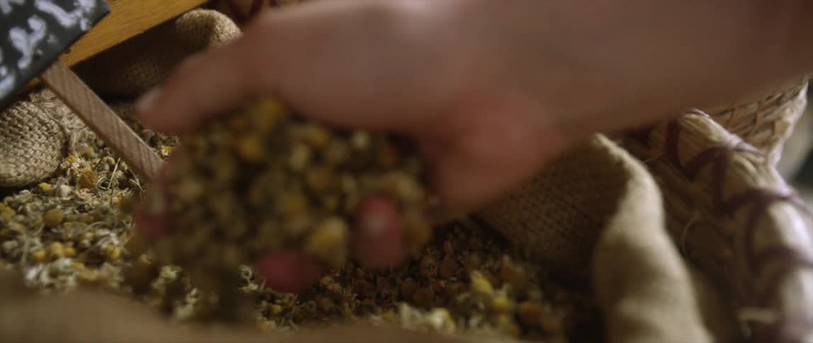 Someone scooping grain from a burlap bag