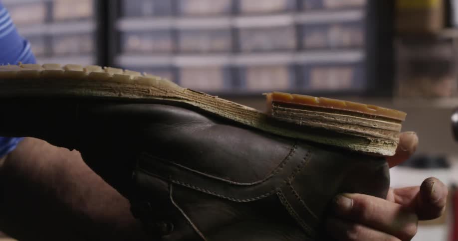 A cobbler attaching a heel to a boot