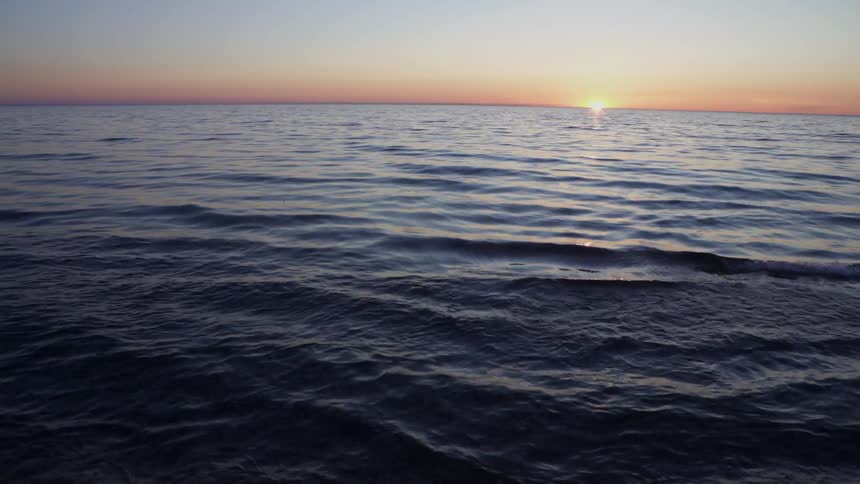 The sun is setting in the distance over an ocean