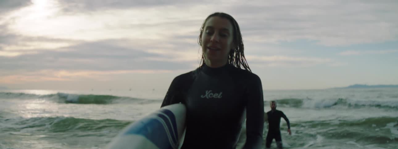 Three surfers with surfboards walking out of the ocean