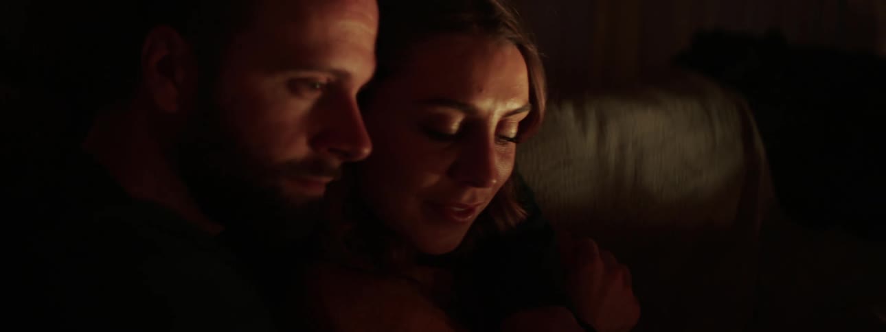 A couple cuddle on the couch together