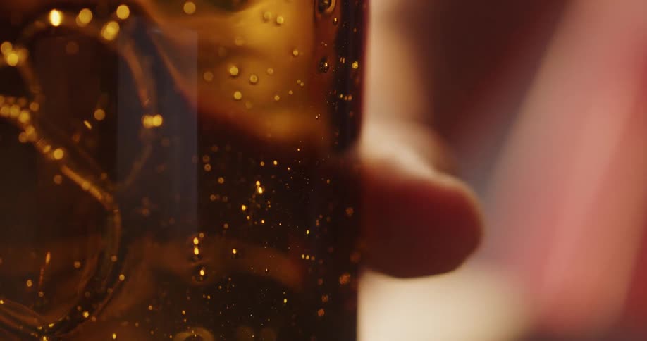 A person picks up a glass and goes to pour the contents in their hand