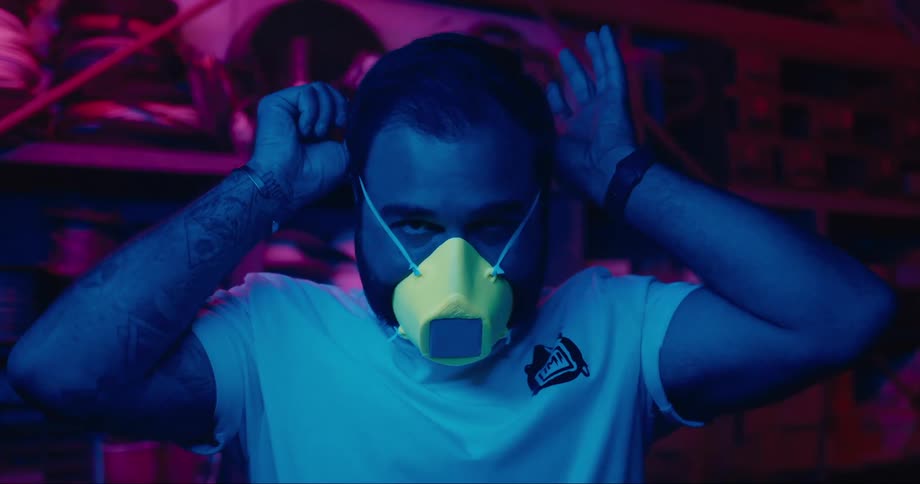Lights flash as a man puts on a face mask that becomes a digital screen