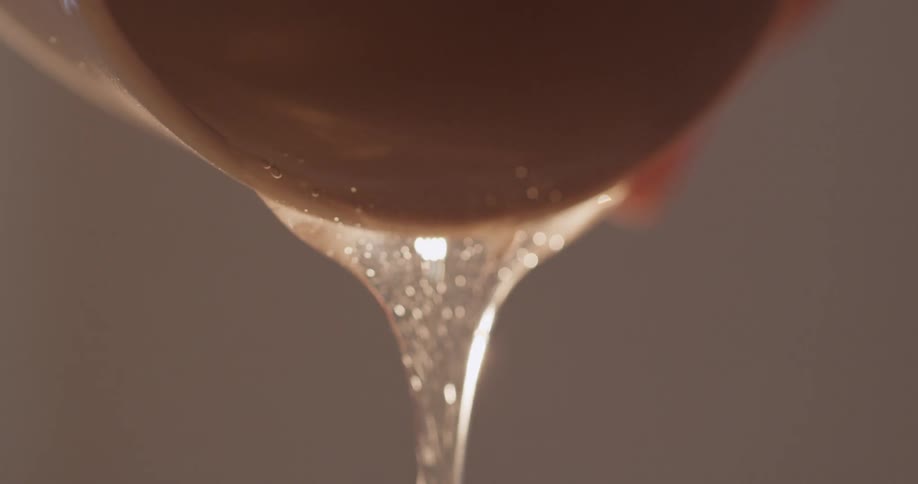 A gel dripping off a sphere with bubbles and light reflecting off of it