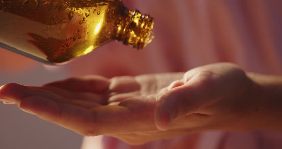 A person with a bottle pouring a gel into their hand