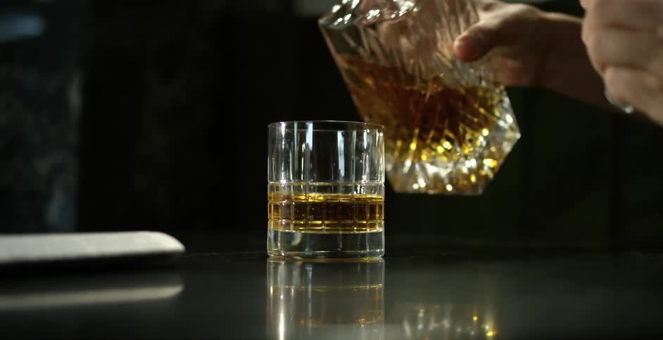 Liquor is poured from a decanter into a glass