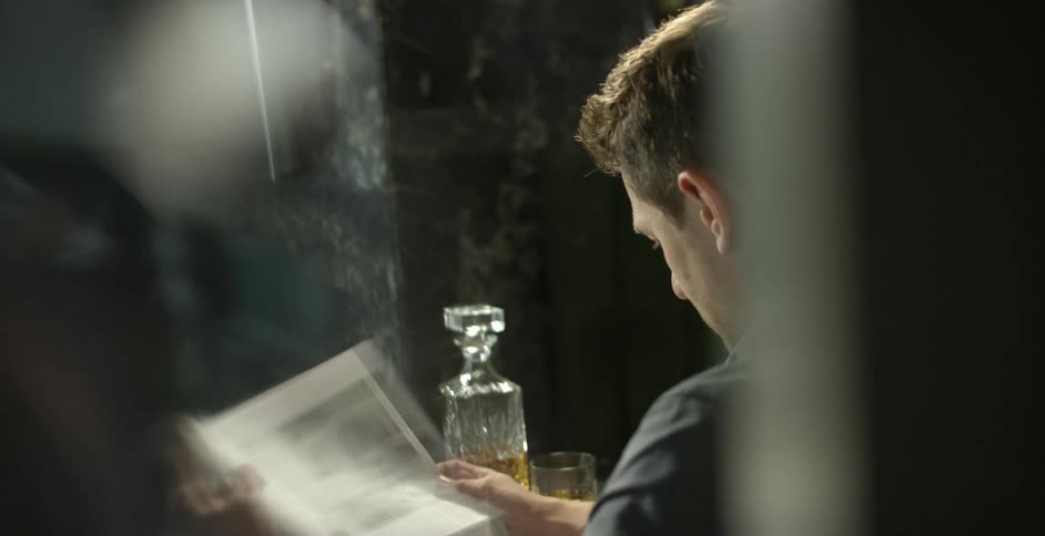 A man is reading a newspaper indoors