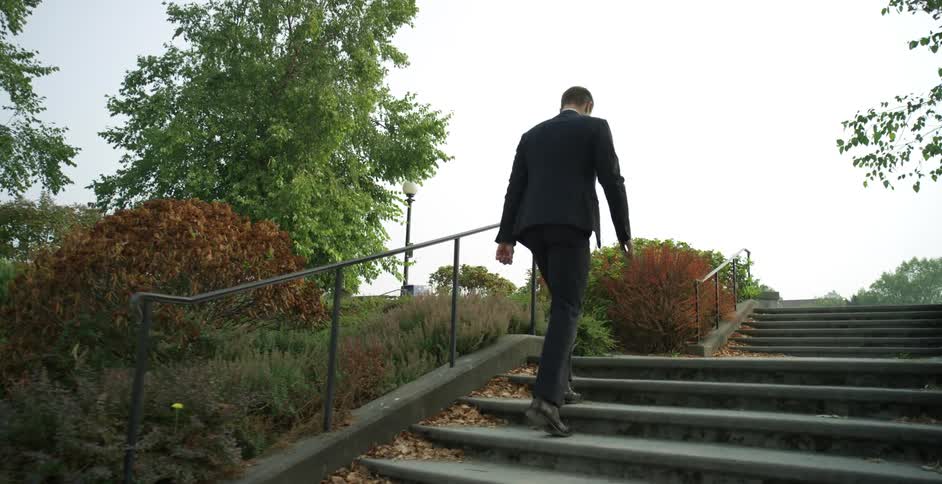A businessman walking up stairs outside
