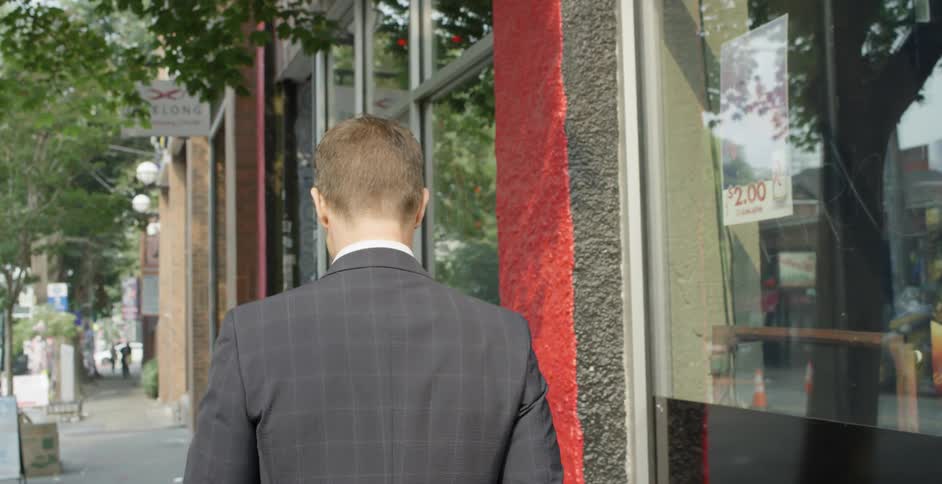 A man is walking outdoors in a city
