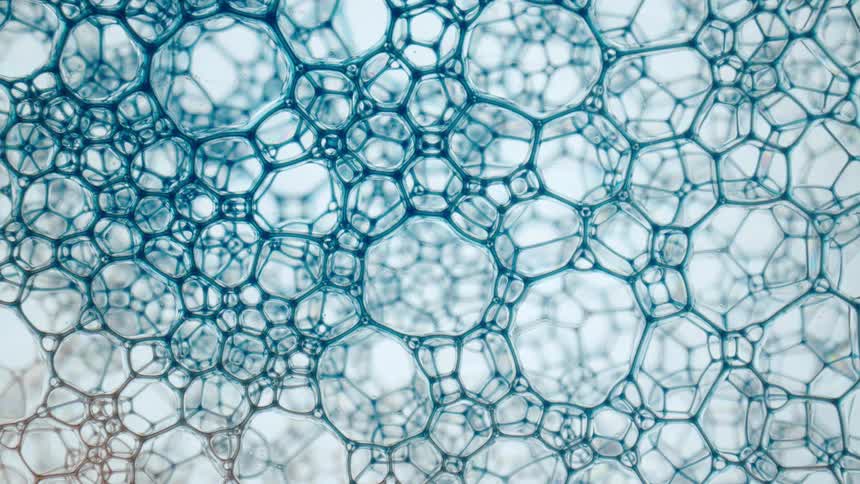 A closeup of a cluster of bubbles has different colors suddenly infused into it