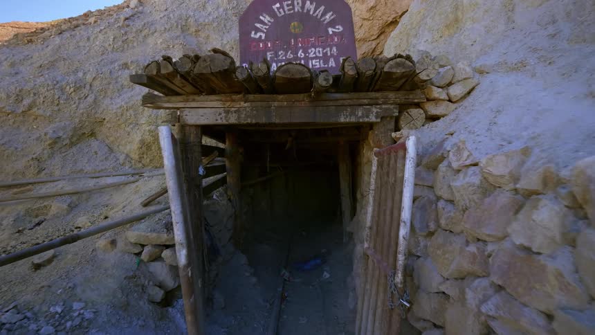 Entrance of an old mine at the side of a mountain in the desert