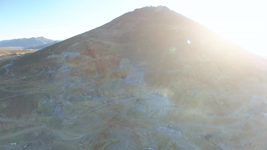 The rising sun is flaring over the edge of the mountain