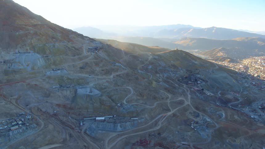 Winding dirt roads connecting patches of buildings on the side of a mountain