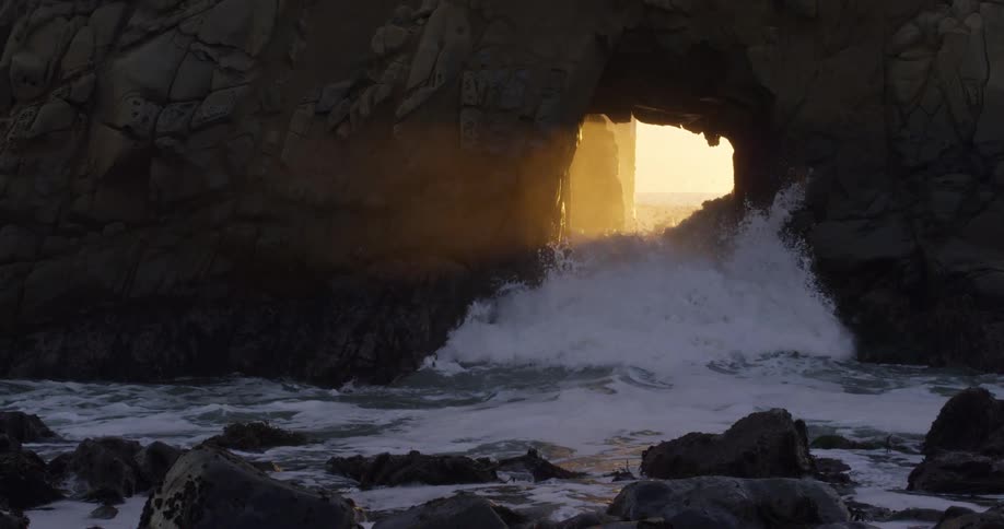 The waves crash through the cave entrance