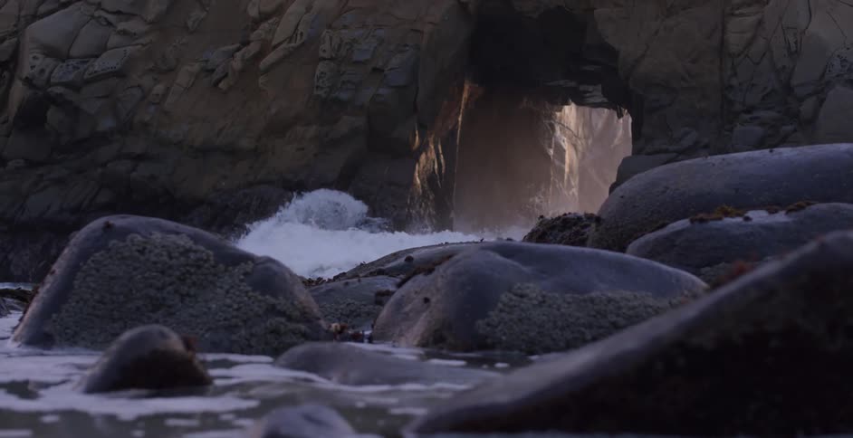 Waves crashing at the base of a canyon