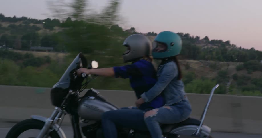 People driving motorcycles down a street