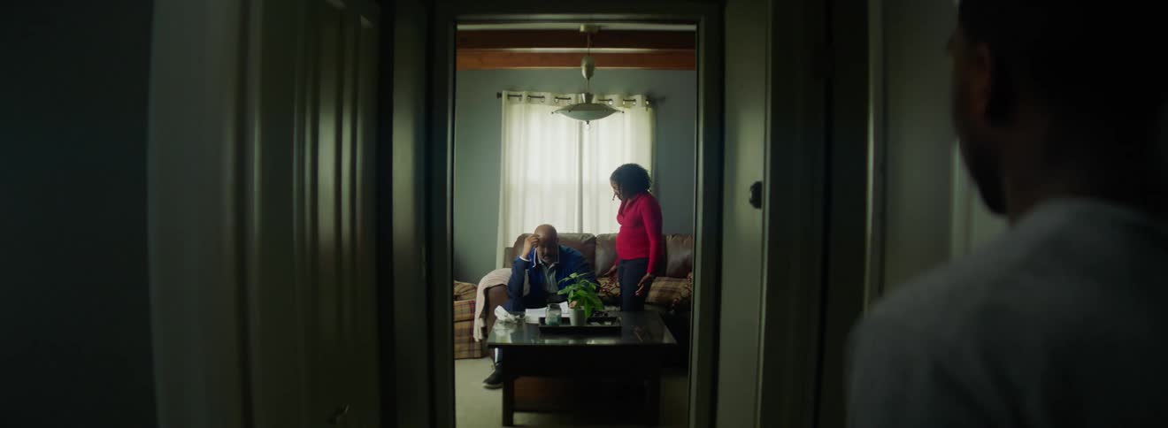 A person watches their parents talk in the living room