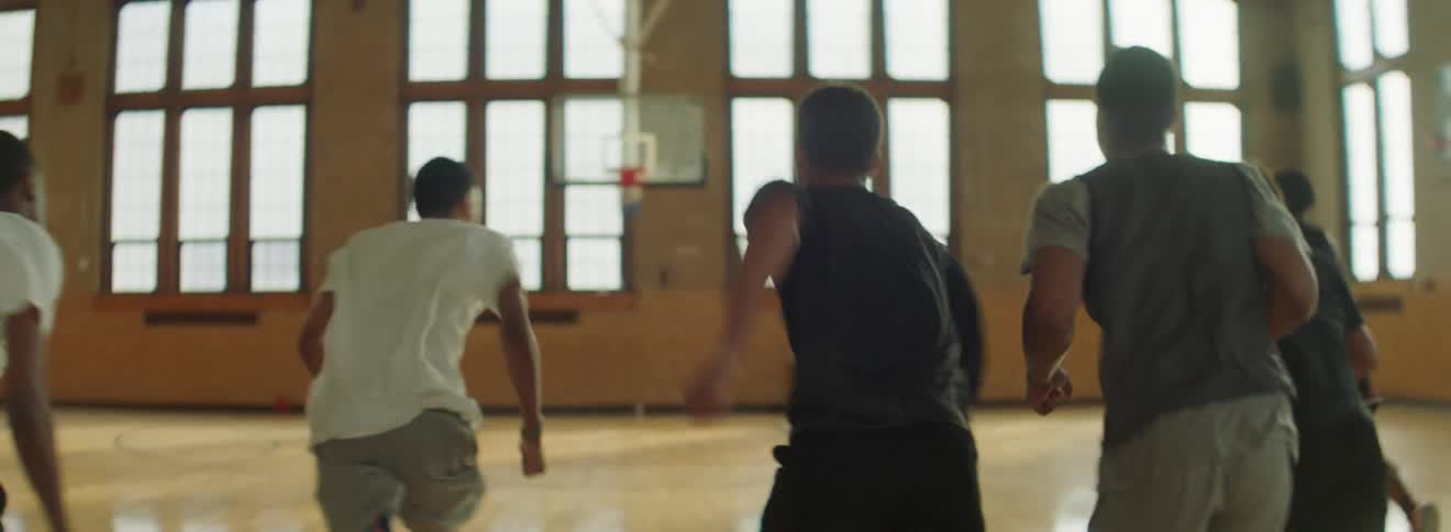 Boys in the gym running with windows in the background