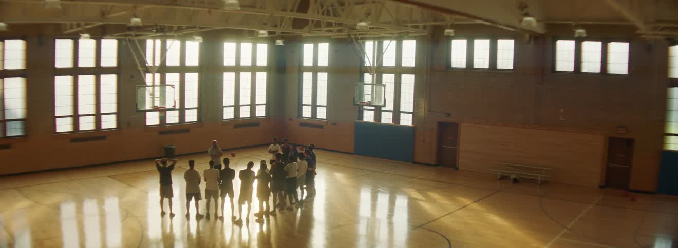 A coach talks to a team in a gymnasium