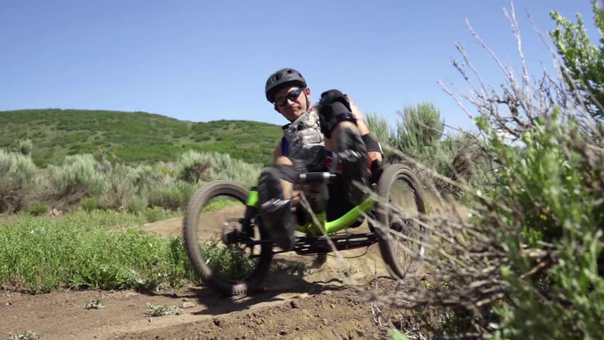 A man cycles on a dirt path