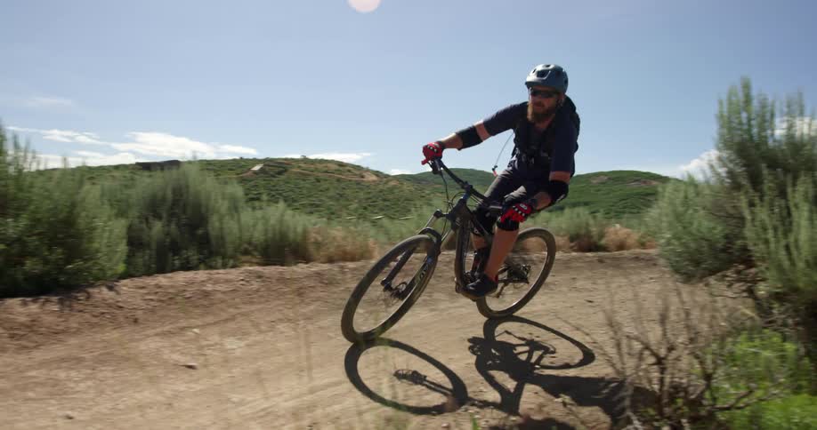 A man rides a mountain bike on a rural dirt path