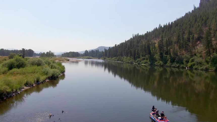 People paddling a boat down a river