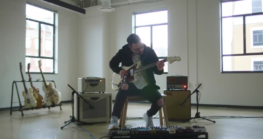 A man playing a guitar inside a building