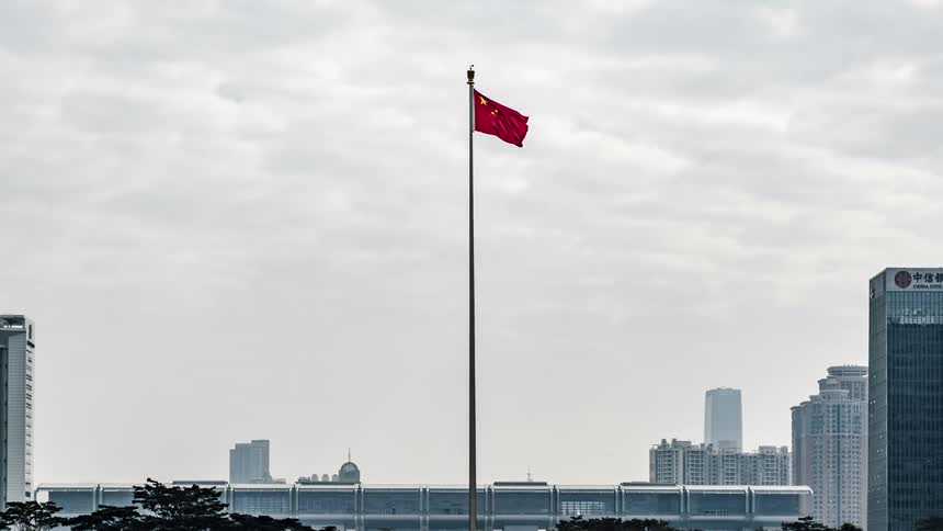 Time lapse of a chinese flag waving in a flagpole in the city at day