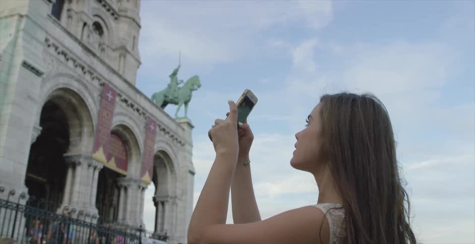 A woman photographing an old building