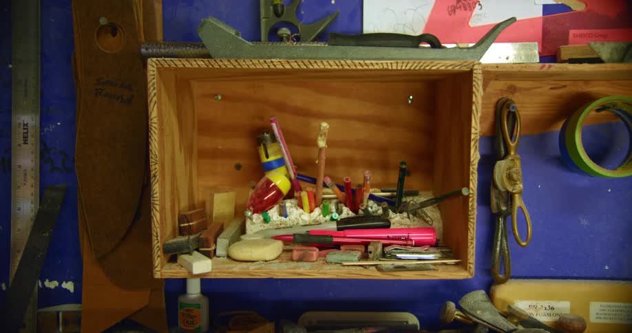 Wooden box shelf on the wall of a workshop filled with tools