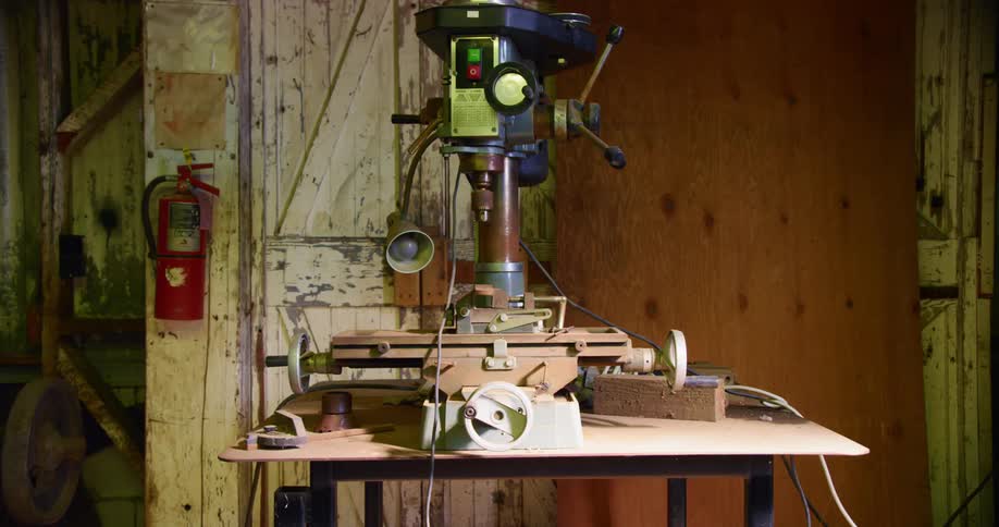 A drill machine sits on the workbench