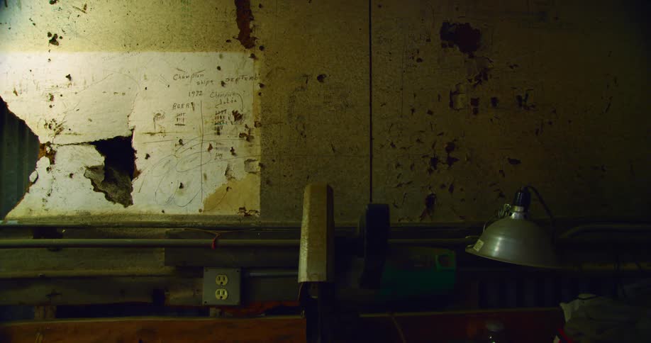 A wall inside is a building that is written on and ripped up